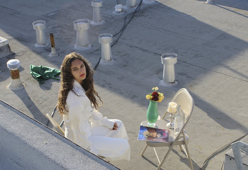 young woman in a white dress on a rooftop